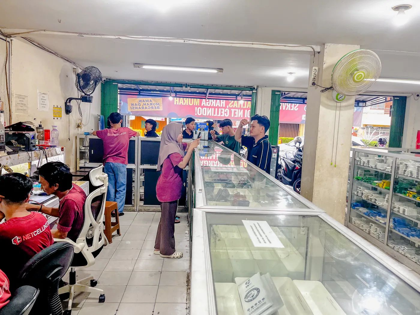 Staf NET CELLINDO Pangkal Pinang melayani pelanggan di meja penerimaan HP