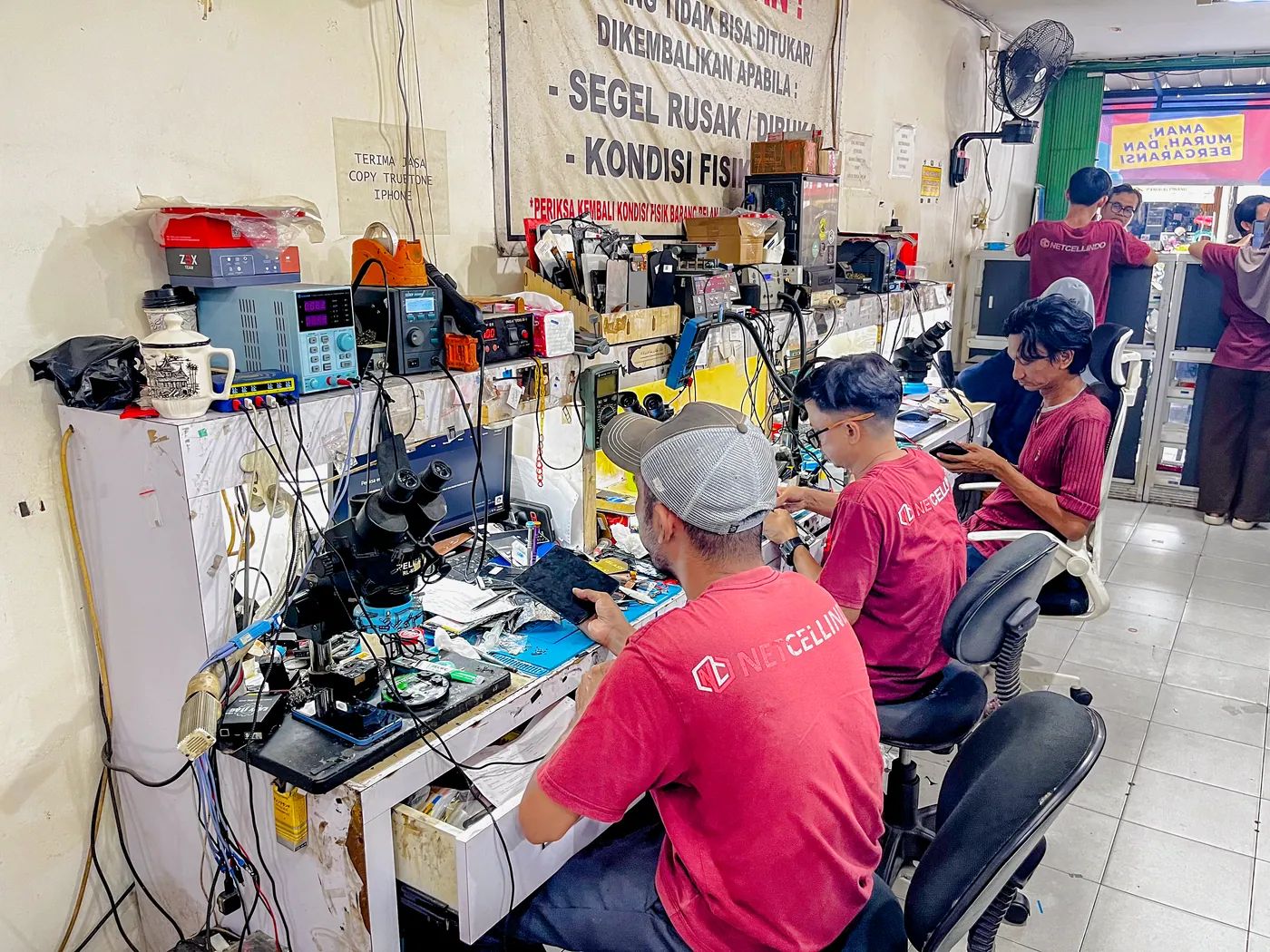 Teknisi NET CELLINDO Pangkal Pinang memperbaiki HP dengan peralatan profesional