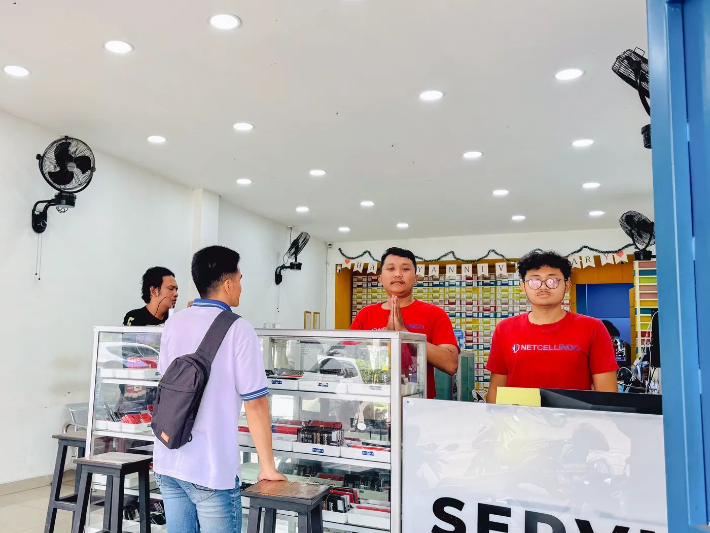 Pelanggan dilayani staf NET CELLINDO Bekasi di meja penerimaan HP