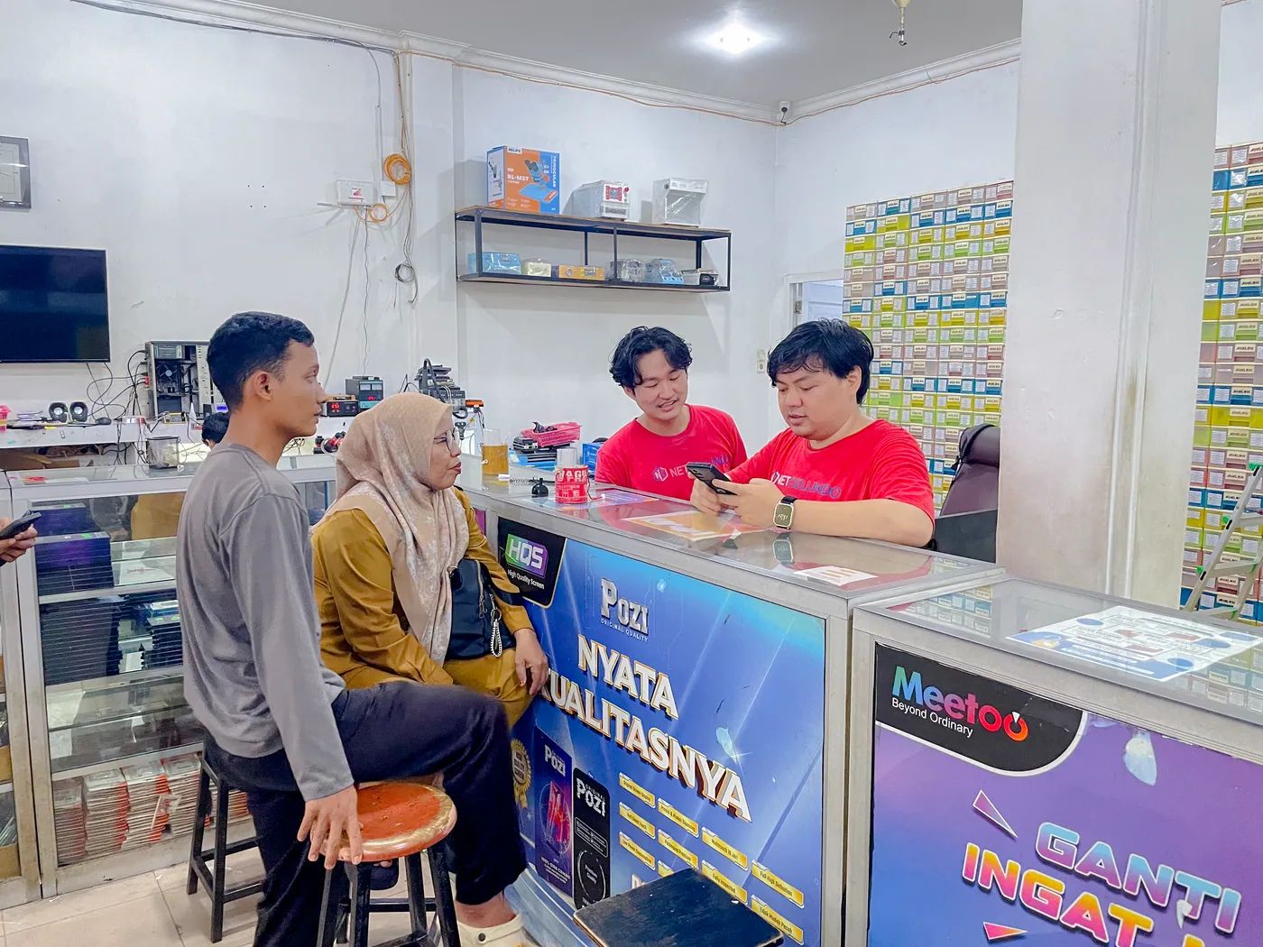 Staf NET CELLINDO Jambi melayani pelanggan di meja penerimaan HP