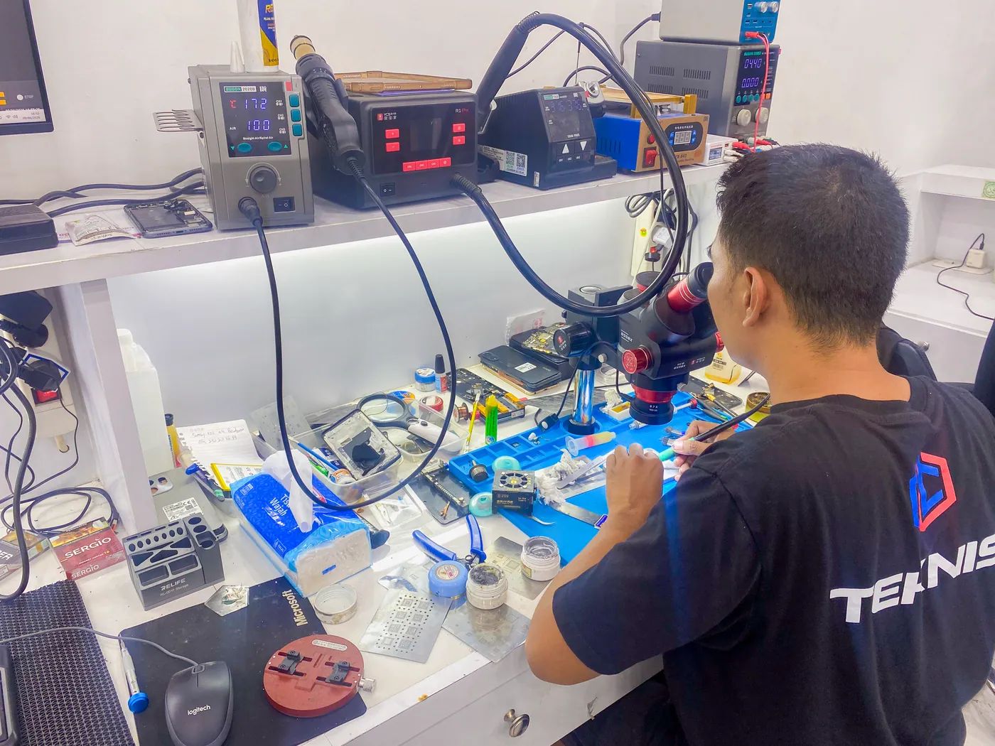 Teknisi NET CELLINDO Makassar memperbaiki HP dengan peralatan profesional