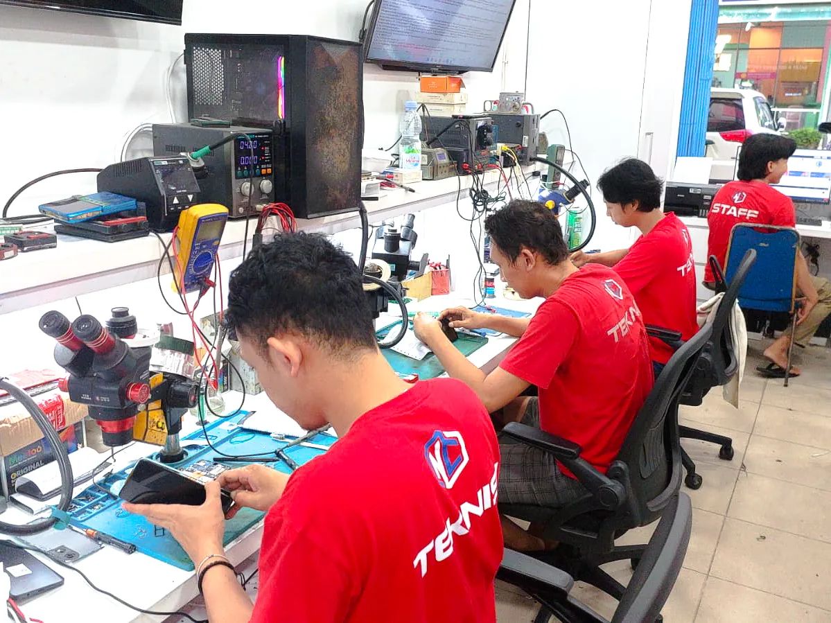 Teknisi NET CELLINDO Palembang PS sedang memperbaiki HP di meja kerja