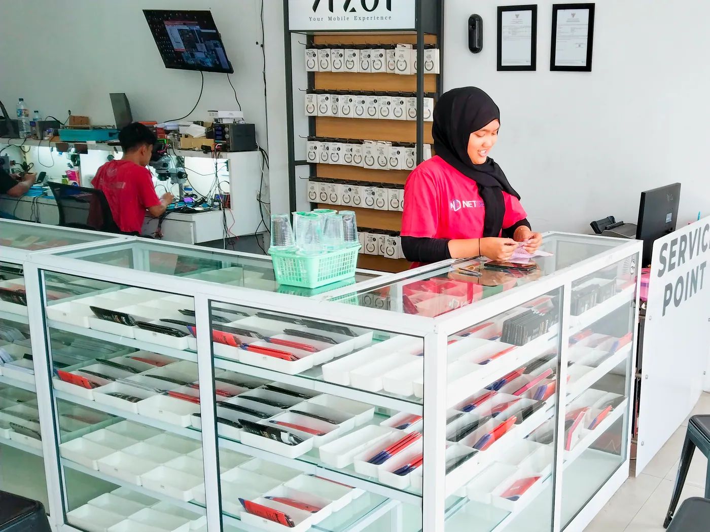 Staf NET CELLINDO Pekanbaru melayani pelanggan di meja penerimaan HP